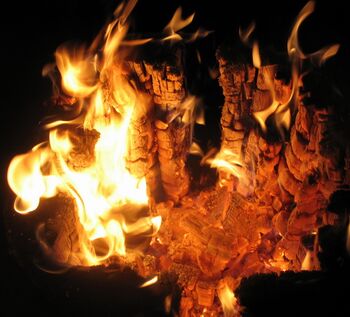 Brennendes Feuerholz am Dorfplatz